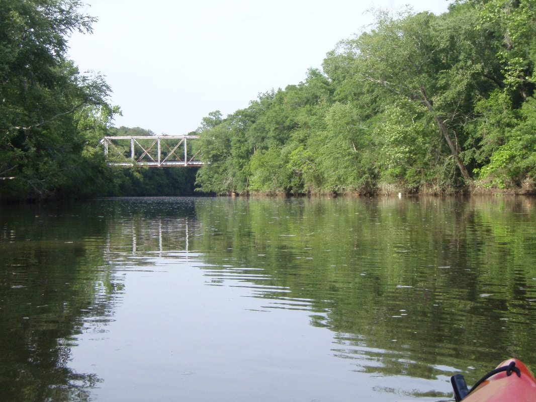 Kayak on a river flowing under a bridge