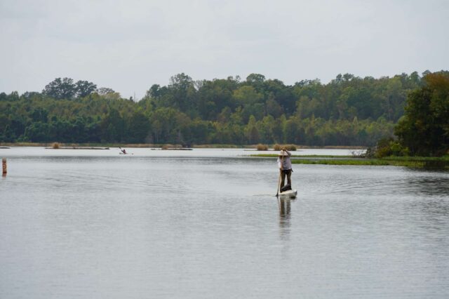 A Woman Standing On A Kayak