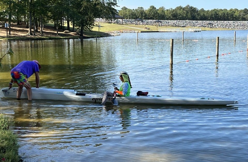 A Group Of People In A Small Boat In A Body Of Water