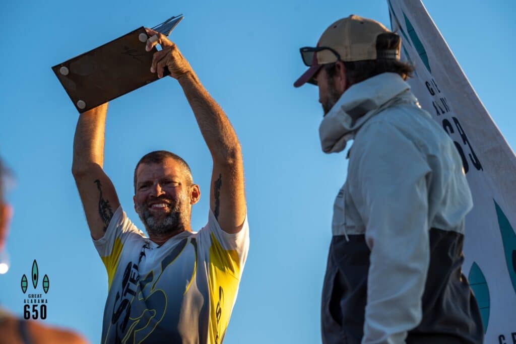 A Man Carrying A Surfboard